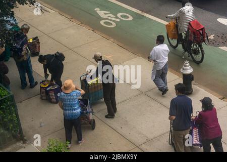 Kunden mit ihren Einkaufswagen, gefüllt mit Großzügigkeit von der Holy Apostles Food Pantry, handeln am Mittwoch, den 1. Juni 2022, in Chelsea in New York. (© Richard B. Levine) Stockfoto