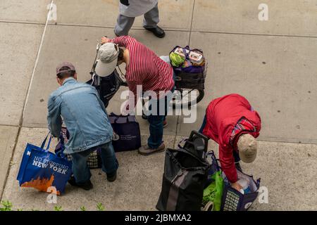 Kunden mit ihren Einkaufswagen, gefüllt mit Großzügigkeit von der Holy Apostles Food Pantry, handeln am Mittwoch, den 1. Juni 2022, in Chelsea in New York. (© Richard B. Levine) Stockfoto