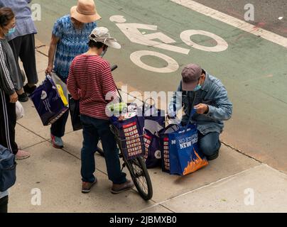 Kunden mit ihren Einkaufswagen, gefüllt mit Großzügigkeit von der Holy Apostles Food Pantry, handeln am Mittwoch, den 1. Juni 2022, in Chelsea in New York. (© Richard B. Levine) Stockfoto