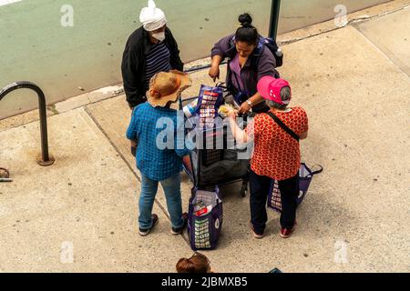 Kunden mit ihren Einkaufswagen, gefüllt mit Großzügigkeit von der Holy Apostles Food Pantry, handeln am Mittwoch, den 1. Juni 2022, in Chelsea in New York. (© Richard B. Levine) Stockfoto