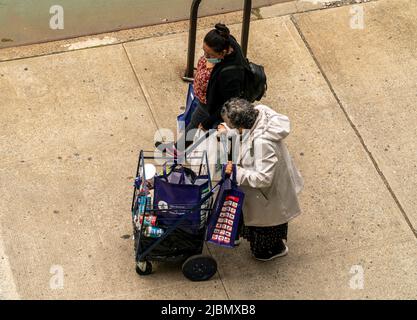 Kunden mit ihren Einkaufswagen, gefüllt mit Großzügigkeit von der Holy Apostles Food Pantry, handeln am Mittwoch, den 1. Juni 2022, in Chelsea in New York. (© Richard B. Levine) Stockfoto