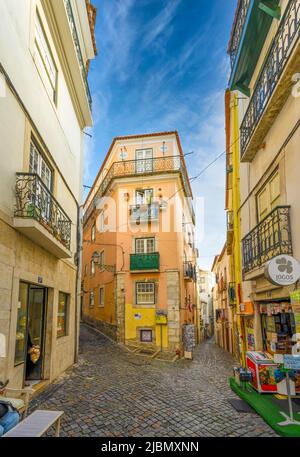 Eine attraktive Kopfsteinpflasterstraße liegt zwischen Reihen alter Häuser im Zentrum von Lissabon, der Hauptstadt Portugals Stockfoto