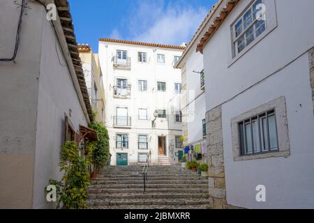 Eine attraktive Kopfsteinpflasterstraße liegt zwischen Reihen alter Häuser im Zentrum von Lissabon, der Hauptstadt Portugals Stockfoto