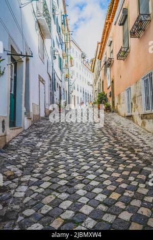 Eine attraktive Kopfsteinpflasterstraße liegt zwischen Reihen alter Häuser im Zentrum von Lissabon, der Hauptstadt Portugals Stockfoto