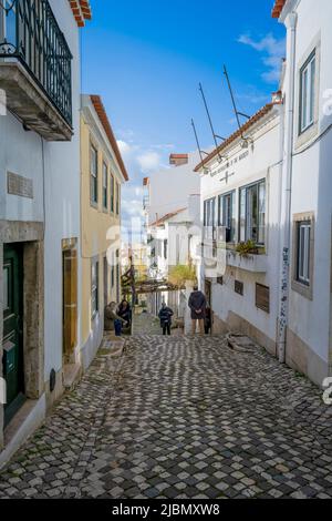 Eine attraktive Kopfsteinpflasterstraße liegt zwischen Reihen alter Häuser im Zentrum von Lissabon, der Hauptstadt Portugals Stockfoto