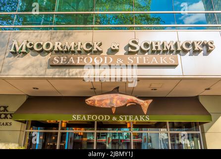 McCormick und Schmicks Außenfassade Marken- und Logo-Signage im Licht der Dämmerung mit hängendem Fischemblem und reflektierendem Glas in Uptown Charlotte. Stockfoto