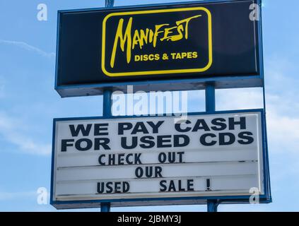 Manifest Discs und Tapes Außenwerbung mit Marken- und Logo-Straßenwerbung vor einem blau-weißen Himmel in Charlotte, North Carolina.
