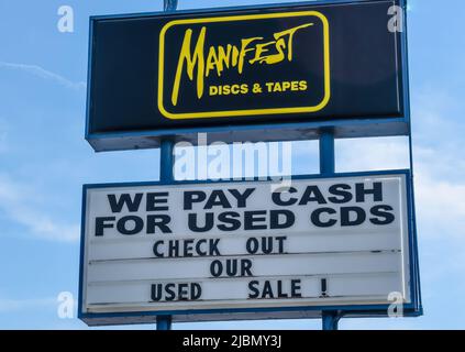 Manifest Discs und Tapes Außenwerbung mit Marken- und Logo-Straßenwerbung vor einem blau-weißen Himmel in Charlotte, North Carolina. Stockfoto