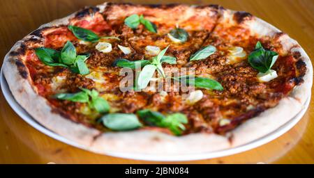 Leckere Bolognese Pizza mit frischem Basilikum Stockfoto