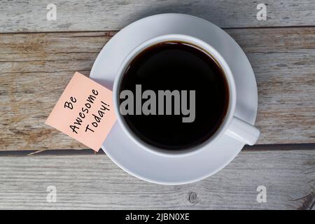 Motivierende und inspirierende Zitat auf Stick Note mit Kaffeetasse - sei genial heute. Stockfoto