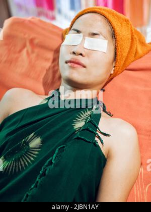 Ein Kunde im Papaya Spa in Vientiane, Laos, hat eine Dampf-Aromatherapie-Gesichtsbehandlung. Der Service umfasst Reinigung, Dampf-Aromatherapie, Peeling und feuchtigkeitsspendende. Stockfoto