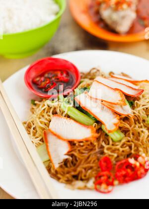 Ein Teller Tok Tok Mee (gebratene Nudeln mit gebratenem Schweinefleisch umrühren); gebratener Zackenbarsch mit Sojasoße und gehackten Chilis; eine Schüssel gedämpften weißen Reis. Penang. Stockfoto