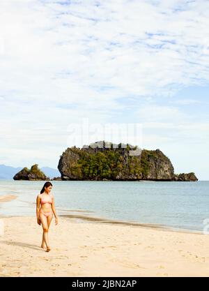 Eine junge malaysische Frau geht auf einer Sandbank in der Tanjung Rhu Cove spazieren. Langkawi, Malaysia. Stockfoto