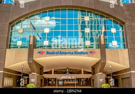 Die Fassade und das Logo des Eingangs zum Bank of America Stadium mit blauem Himmel und Wolken spiegeln sich in den Glasfenstern über den Türen wider. Stockfoto