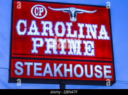 Carolina Prime Steakhouse, freistehend beleuchtete Straßenwerbung in weißen Buchstaben auf rotem Hintergrund vor blauem Himmel. Stockfoto