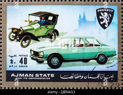 AJMAN - UM 1972: Eine im Ajman gedruckte Briefmarke zeigt Peugeot, Cars damals und heute, um 1972 Stockfoto