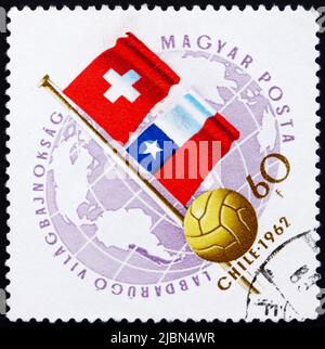 UNGARN - UM 1962: Eine in Ungarn gedruckte Marke zeigt Globe, Ball und Flaggen der Schweiz und Chiles, WM-Fußballmeisterschaft, Chile, um Stockfoto