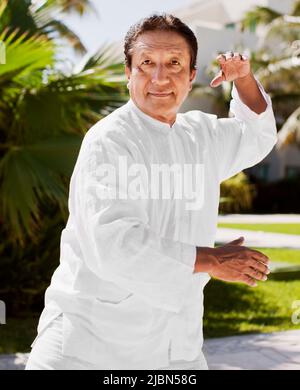 Victor, ein Tai-Chi-Lehrer, ruft im Rahmen des Ara-Rituals Billy, den Papagei, an – eines von mehreren täglichen Ritualen, die im Live Aqua Resort stattfinden Stockfoto