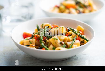 Nudelsalat mit gegrilltem Gemüse, Zucchini, Auberginen, Spargel und Tomaten. Stockfoto