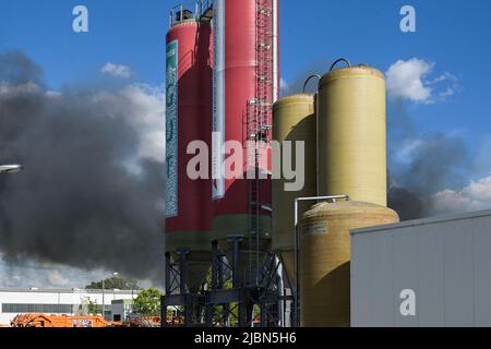 07. Juni 2022, Sachsen-Anhalt, Halle (Saale): Eine Wolke aus schwarzem Rauch driftet über das Firmengelände. Im Recyclingzentrum des Stadtwerke Halle brannte ein Radlager aus. Mehrere Feuerwehren wurden eingesetzt. Foto: Heiko Rebsch/dpa Stockfoto