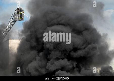 07. Juni 2022, Sachsen-Anhalt, Halle (Saale): Feuerwehrleute versuchen, das Feuer zu löschen. Im Recyclingzentrum der Halleschen Stadtwirtschaft brannte ein Radlager. Mehrere Feuerwehr waren im Einsatz. Foto: Heiko Rebsch/dpa Stockfoto