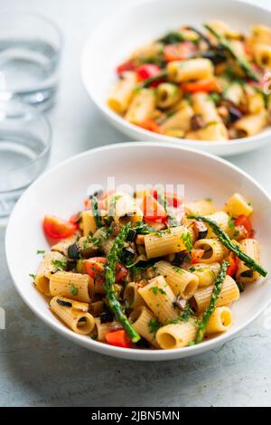 Nudelsalat mit gegrilltem Gemüse, Zucchini, Auberginen, Spargel und Tomaten. Stockfoto