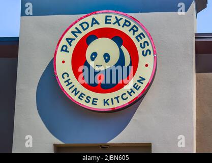 Panda Express Chinese Kitchen hat eine kreisförmige Außenfassade mit Marken- und Logo-Schilder in Rot, Schwarz und Weiß bei strahlendem Sonnenschein und Schatten. Stockfoto