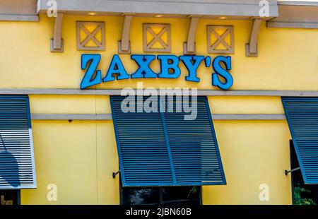 Zaxby's Restaurant Außenfassade Marke und Logo Beschilderung in pulverblauen Buchstaben auf einem gelb beigen Gebäude mit Fensterblenden an einem hellen sonnigen Tag. Stockfoto