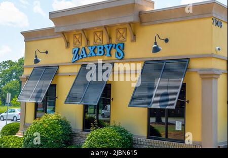 Zaxby's Restaurant Außenfassade Marke und Logo Beschilderung in pulverblauen Buchstaben auf einem gelb beigen Gebäude mit Fensterblenden an einem hellen sonnigen Tag. Stockfoto