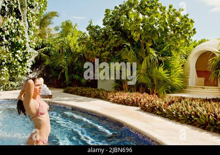 Eine Frau verlässt das Dampfbad während einer traditionellen mexikanischen Temezcal-Behandlung im Spa Aqua im Live Aqua Resort & Spa. Stockfoto