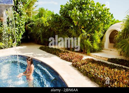 Eine Frau verlässt das Dampfbad während einer traditionellen mexikanischen Temezcal-Behandlung im Spa Aqua im Live Aqua Resort & Spa. Stockfoto