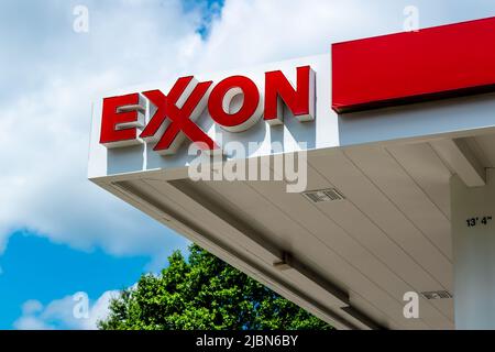 Die Außenfassade der Exxon-Tankstelle und das Logo in roten Buchstaben auf Weiß vor einem blauen Himmel mit weißen Wolken im Südwesten von Charlotte, NC. Stockfoto