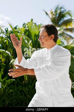 Victor, ein Tai-Chi-Lehrer, ruft im Rahmen des Ara-Rituals Billy, den Papagei, an – eines von mehreren täglichen Ritualen, die im Live Aqua Resort stattfinden Stockfoto