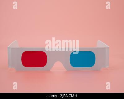 Rote und blaue Papiergläser für 3D Filme und Bilder. Isoliert auf einem rosa Hintergrund. Stockfoto
