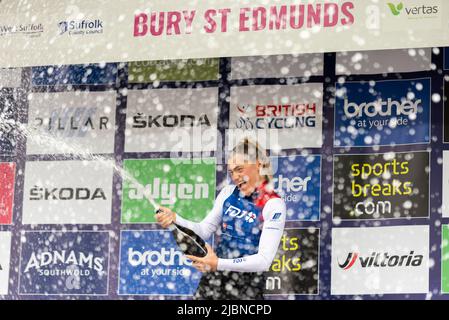 Clara Copponi vom Team FDJ, Gewinnerin des Radrennens der UCI Women’s Tour 1 in Bury St. Edmunds, feiert auf dem Podium Champagner Stockfoto