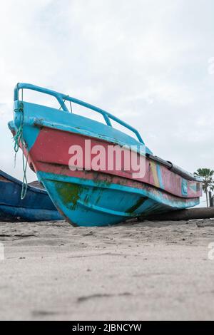 Kleines Boot im Sand am Strand verankert, Transportmittel und Werkzeug zum Angeln, Hintergrund mit Objekt Stockfoto