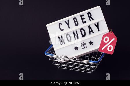 Cyber monday geschrieben in Buchstaben auf Leuchtkasten im Warenkorb, schwarzer freitag Konzept auf dunklem Hintergrund Stockfoto