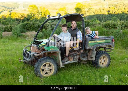 Jungen in einem John Deere Gator Utility Vehicle, High Bickington, Devon, England, Vereinigtes Königreich. Stockfoto