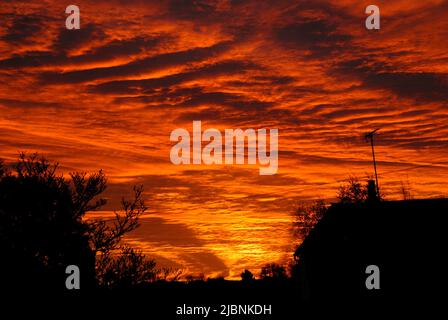 Herrlicher Sonnenaufgang mit der Sonne, die auf der Unterseite der Wolken scheint Stockfoto