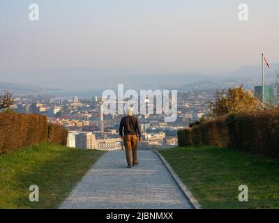 Zürich, Schweiz - 26. 2022. März: Ein Mann, der auf einem Fußweg mit herrlichem Blick über die Stadt läuft. Stockfoto