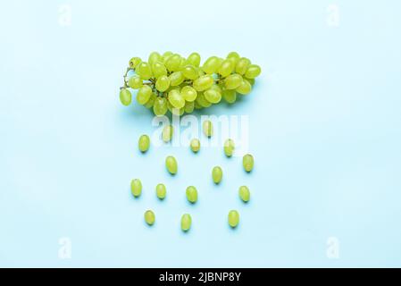 Wolken- und Regentropfen aus grünen Trauben auf farbigem Hintergrund Stockfoto