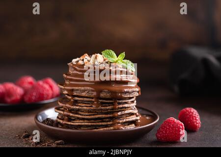 Stapel von Schokoladenpfannkuchen mit Sauce und Himbeeren Stockfoto