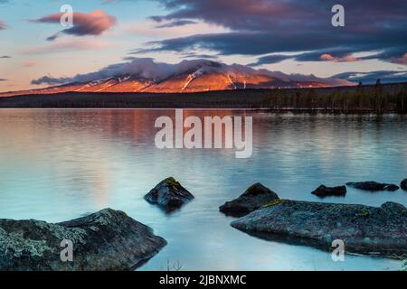 Frühmorgens goldener Stundenalpenglow auf dem Berg Sølen, vom See Isteren in Engerdal kommune, Norwegen, Skandinavien gesehen. Stockfoto