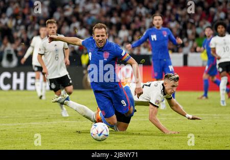 Der englische Harry Kane (links) wird von Nico Schlotterbeck, dem deutschen Fußballnationalmannschaft, angefichtert, was nach einer VAR-Überprüfung während des Spiels der UEFA Nations League in der Allianz Arena in München zu einer Strafe führt. Bilddatum: Dienstag, 7. Juni 2022. Stockfoto
