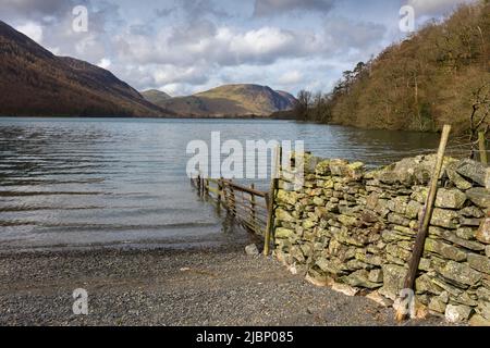 Das Ufer des Buttermere Lake bei Hassness Crag Wood mit Mellbreak Beyond im Frühjahr im Lake District National Park, Cumbria, England. Stockfoto