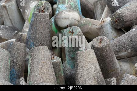 Betonbruchwässer aus Tetrapodenblöcken. Wellenbrecher am Strand und in den Dünen. Betonblöcke am Strand. Stockfoto