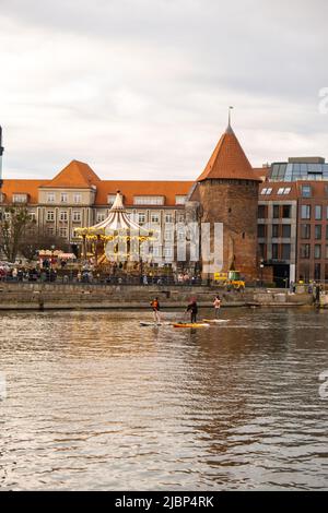 Danzig Polen März 2022 Gruppe von Sup-Surfern stehen auf Paddle-Board, Frauen stehen auf Paddeln zusammen in der Stadt Motlawa Fluss und Kanal in der Altstadt Danzig Polen. Tourismusattraktion Aktive Erholung im Freien Soziale Distanzierung Reiseziele Stockfoto