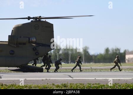 Soldaten verlassen einen CH-47 Chinook Hubschrauber während einer Luftangriffsmission, um die 11. Airborne Division Aktivierungszeremonie am 6. Juni 2022 im Ladd Army Airfield auf Fort Wainwright, Alaska, zu starten. Soldaten des Stryker Brigade Combat Teams 1. tauschten ihre 25. Patches der Infanterie-Division gegen die der historischen Airborne Division 11. ein und werden in Alaska als 1. Brigade Combat Team der „Arctic Angels“ dienen, das sich auf Einsätze bei extremer Kälte und in gebirgigen Höhenlagen spezialisiert hat. (Foto der Armee/John Pennell) Stockfoto