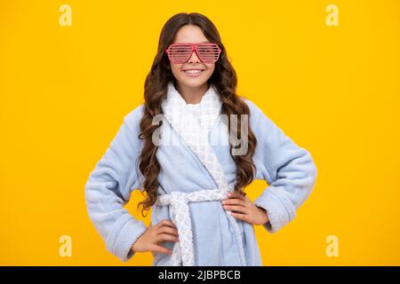 Porträt von lustigen Teenager-Mädchen in lustigen Brillen und Pyjama oder zu Hause Bademantel Gefühl Spaß isoliert auf gelbem Hintergrund. Stockfoto