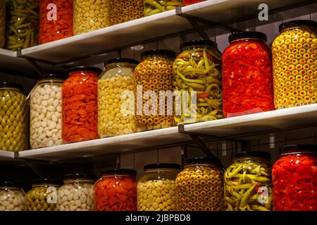 Eingelegtes Gemüse in Gläsern auf dem Regal in der Speisekammer. Stockfoto